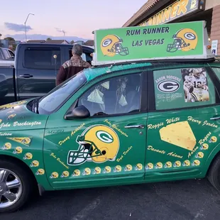 a green and yellow car with a sign on top