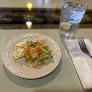 a plate of salad and a glass of water