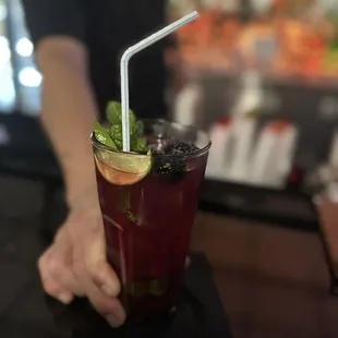 a person holding a drink with a straw