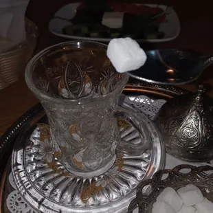 sugar cubes in a glass on a silver tray