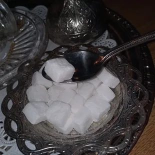 a bowl of sugar cubes and a spoon