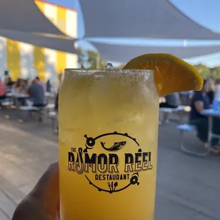 a person holding a glass of orange juice