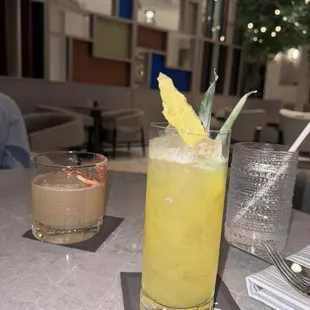 a glass of orange juice with a pineapple garnish