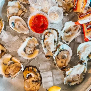 a platter of oysters with a side of ketchup