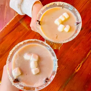 two people holding glasses of drinks