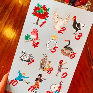 a person holding a card with a picture of a number of animals