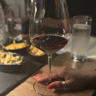 a woman&apos;s hand holding a glass of wine