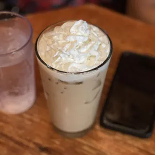 a glass of iced coffee with whipped cream