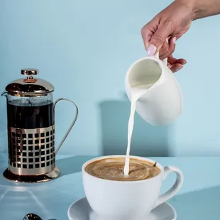 a person pouring milk into a cup