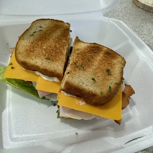 Classic Club-$12.99 Served with ham, turkey &amp; Swiss or cheddar cheese along with bacon, romaine, tomato &amp; mayo on toasted bread.