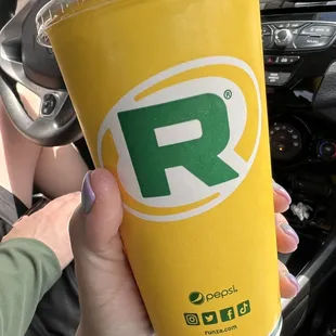 a person holding a drink in their hand