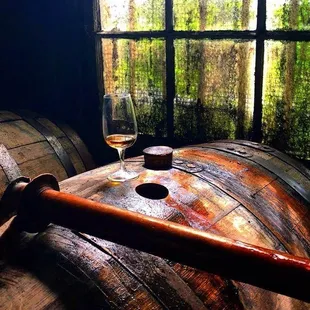 a glass of wine on a barrel