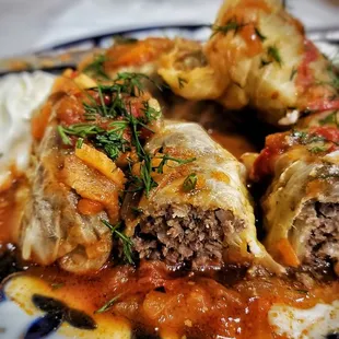 Goluptsi - Cabbage leaves stuffed with seasoned ground beef and rice, served with sour cream and tomato sauce.