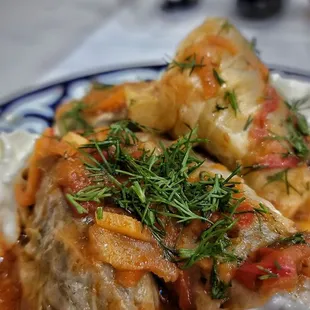 Goluptsi - Cabbage leaves stuffed with seasoned ground beef and rice, served with sour cream and tomato sauce.