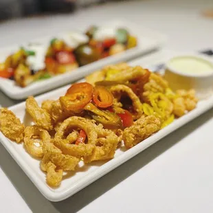 a plate of fried squid rings and a plate of salad
