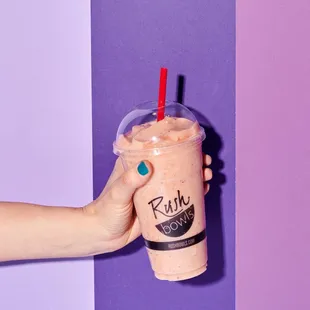 a hand holding a smoothie