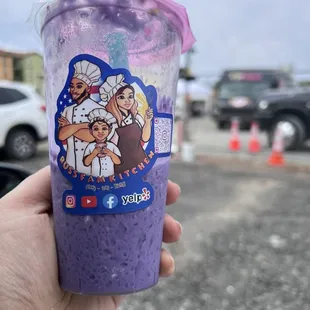 a hand holding a purple drink