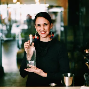 a woman holding a bottle of gin
