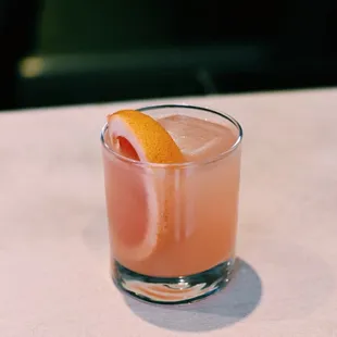 a pink drink with orange wedge
