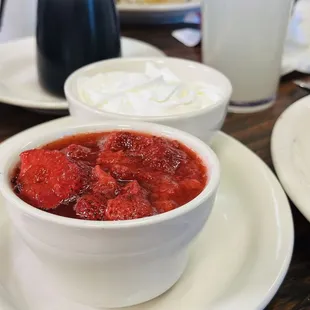 a bowl of strawberries and whipped cream