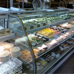 a woman looking at a display case of pastries