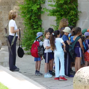 a woman talking to a group of children