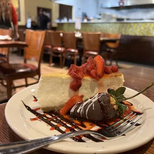 a piece of cheesecake with strawberries and chocolate sauce