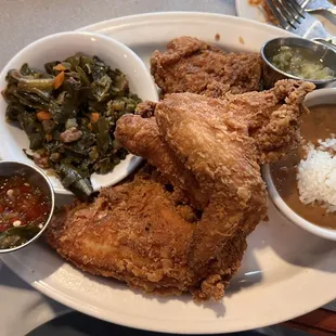 NOLA fried chicken.  A huge portion with four pieces, two kinds of relish, collard greens, and red beans and rice.