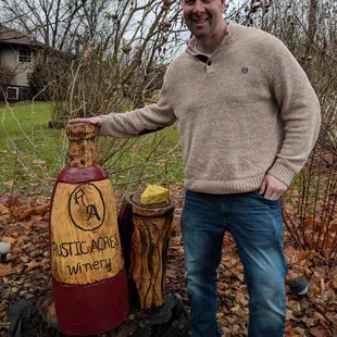 a man standing next to a bottle of wine