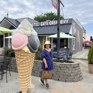 a woman standing in front of an ice cream cone