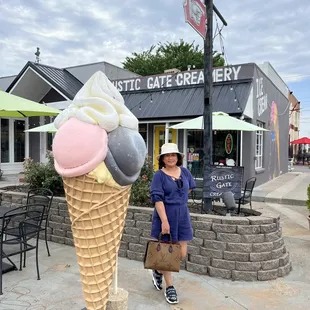 a woman standing in front of an ice cream cone