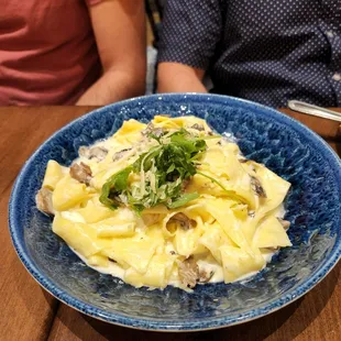 a plate of pasta with mushrooms and parsley