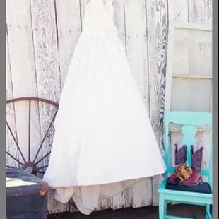 Beautiful way to display the dress with a pop of color from the Teal Chair, add the trunk, wagon wheel, window, and a barn!