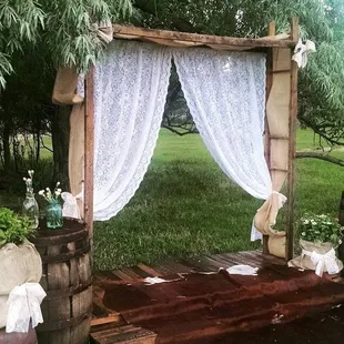Wooden Arch and Platform with Burlap and Lace, Authentic Cow Hide, Whiskey Barrels, jars, and some greenery!