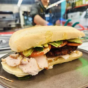 Chicken Club is made with oven-roasted chicken breast, provolone, peppered bacon, avocado, tomatoes, French Bun.