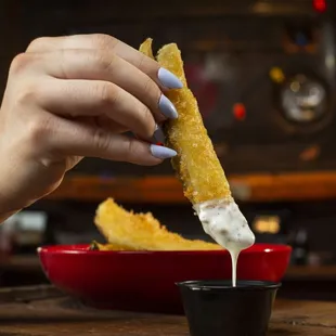 a person dipping a piece of bread