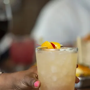 a woman holding a glass of cocktail