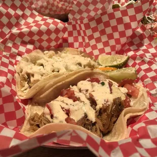 two tacos in red and white checkered paper