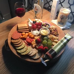 a platter of cheese, crackers, and grapes