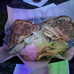 a sandwich with chips and a drink