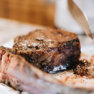 a person cutting a steak