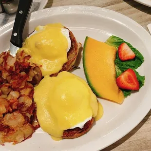 Sausage patty eggs Benedict comes with potatoes or fruits on the side