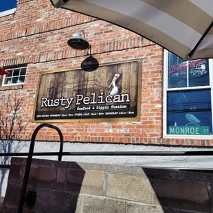 a brick building with a sign for rusty pelican