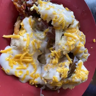 Heart attack on a plate, AKA breakfast "Topper #2". Biscuits topped w/ bacon, eggs, grilled onions, home fries, gravy &amp; cheese.