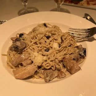 a plate of pasta with chicken and mushrooms