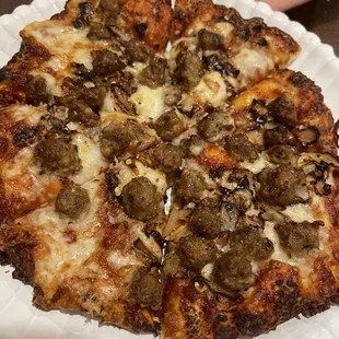 a pizza on a paper plate