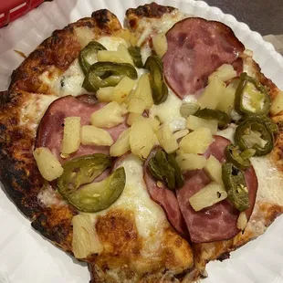 a pizza on a paper plate