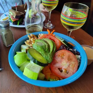 a bowl of salad and a glass of wine