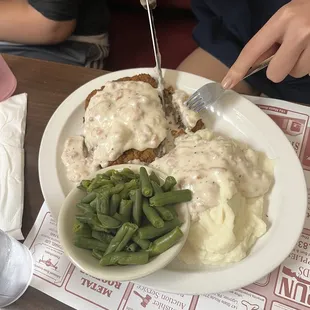 Chicken fried steak with green beans and sausage gravy.
