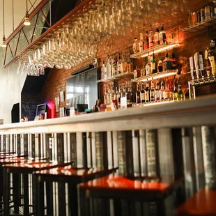 a bar with a lot of wine glasses hanging from the ceiling
